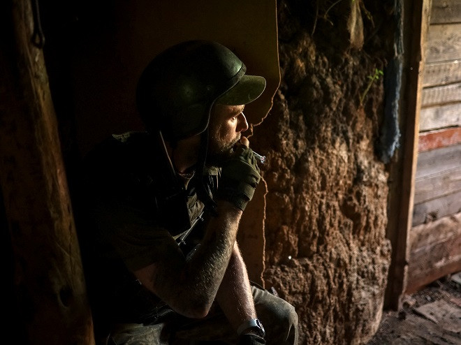 ޔޫކްރެއިންއަށް ރަޝިޔާއިން ދެމުންގެންދާ ހަމަލާގައި، ޔޫކްރެއިންގެ ސާވިސް މެމްބަރަކު ކުރީ ސަފުގައި ހުރެ، ޓްރެންޗެއްގައި ދުންފަތުގެ އިސްތިއުމާލު ކުރަނީ - ފޮޓޯ: ރޮއިޓަރސް