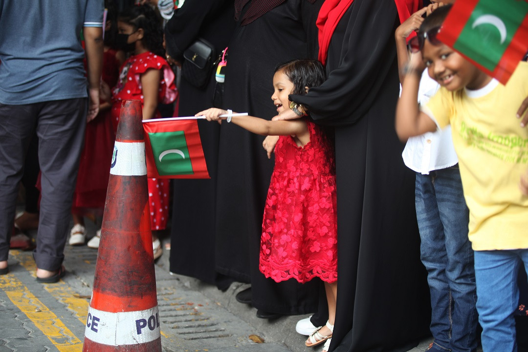 ރާއްޖޭގެ 57 ވަނަ މިނިވަން ދުވަހުގެ ޕެރޭޑް ބަލާލަން ނުކުމު ހުރި ކުޑަކުއްޖެއް ދިވެހި ދިދަ ހިފައިގެން - ފޮޓޯ: އަހުމަދު ސިރާޖް