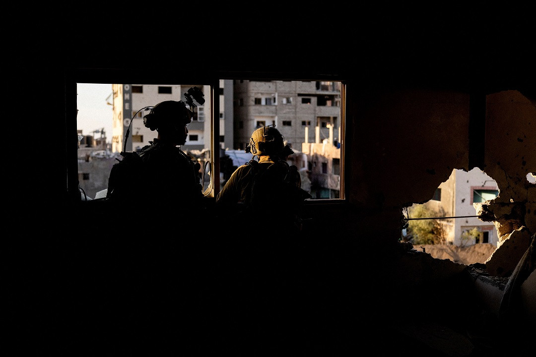 ޣައްޒާއަށް އަރައިގެން އުޅޭ އިސްރާއީލުގެ އަސްކަރީ އޮފިސަރުންތަކެއް، އެމީހުންގެ ބޮމުގެ ހަމަލާތަކުގައި ގެއްލުންލިބިފައިވާ ގެއެއްގެ ތެރޭގައި - ފޮޓޯ: ރޮއިޓަރސް