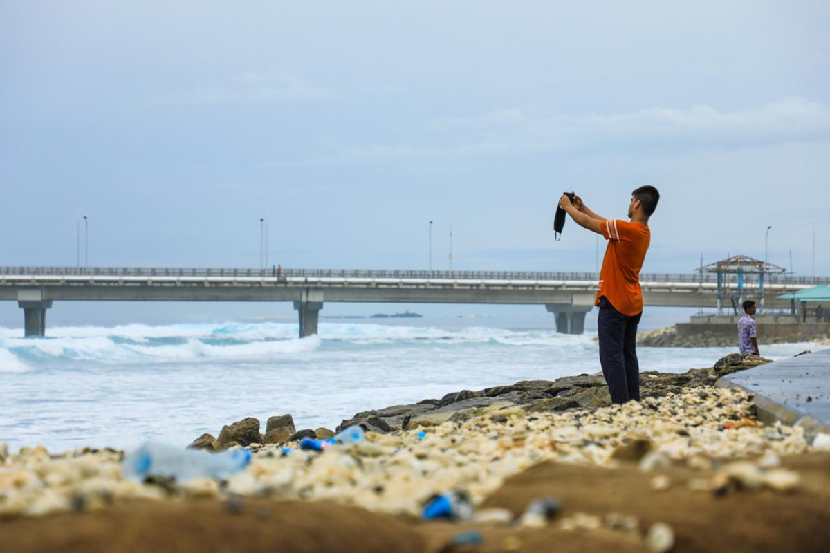 ބްރިޖް ސަރައްދު އަތިރިމަތީގައި މީހަކު ހުއްޓިލައިގެން ފޮޓޯއެއް ނަގަނީ - ފޮޓޯ:ރާއްޖެއެމްވީ