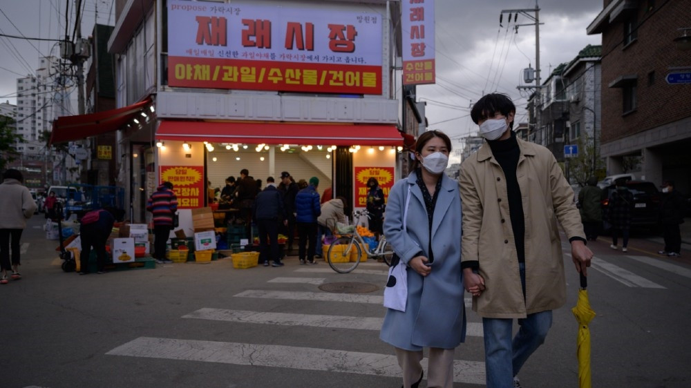 ދެކުނު ކޮރެއާގައި މަގެއްގެ މަތީގައި މީހުން މާސްކު އަޅައިގެން