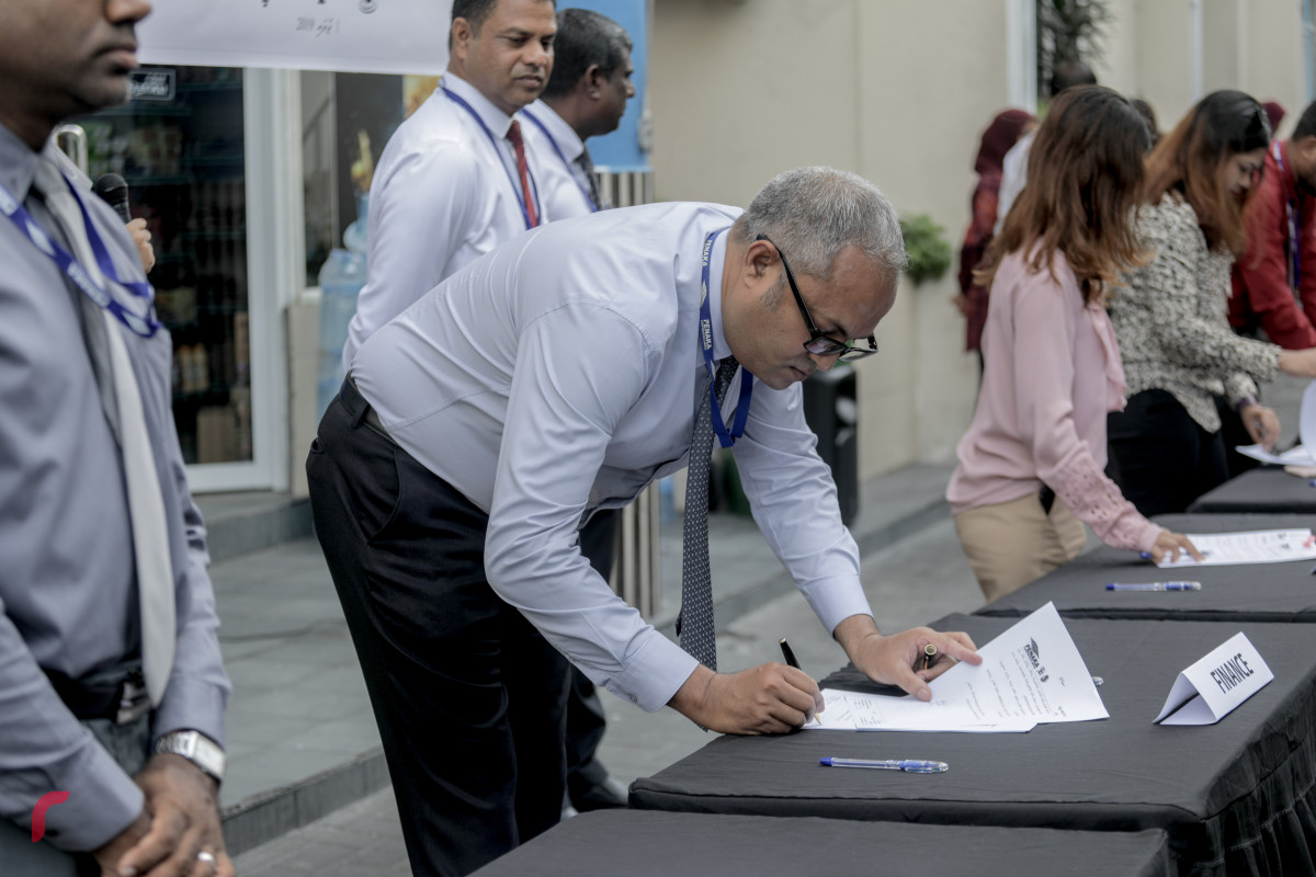 1 ޖުލައި 2019 --ފެނަކަ ކޯޕަރޭޝަންގެ މުއައްޒަފުން ކުރަޕްޝަނައާއި ދެކޮޅަށް ސޮއިކުރުމަށް ބޭއްވި ހަރަކާތުގެ ތެރެއިން. ފެނަކައިގެ ހުރިހާ މުވައްޒަފުން ވަނީ މި އިގުރާރުގައި ސޮއިކޮށްފައި.-- ފޮޓޯ: ޝުއައިބް މުހައްމަދު